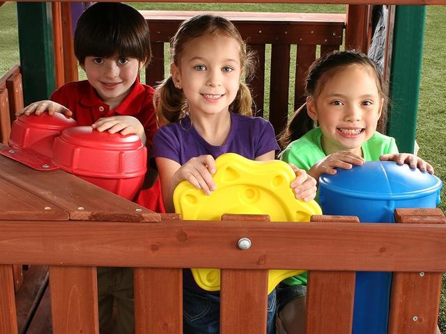 Children playing a rhythm band kit on a fort deck
